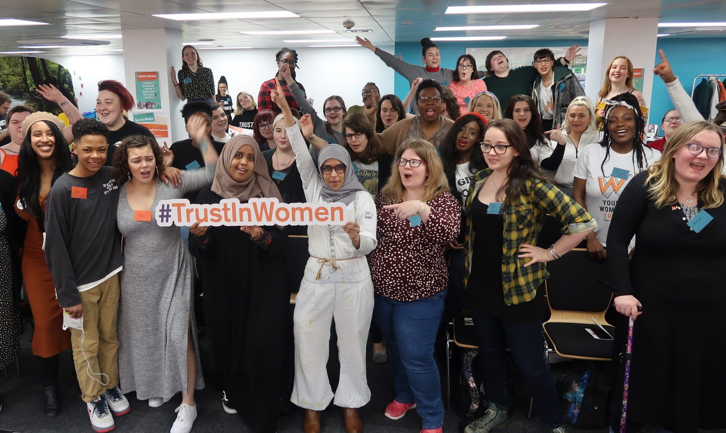 Group of women holding a #TrustInWomen sign