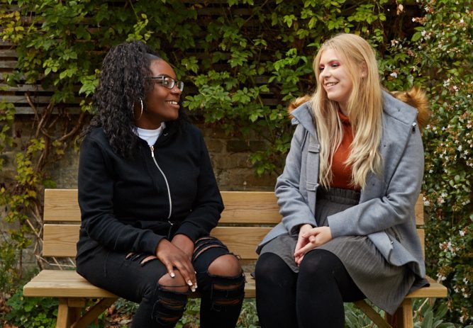 Two young women chatting in a garden