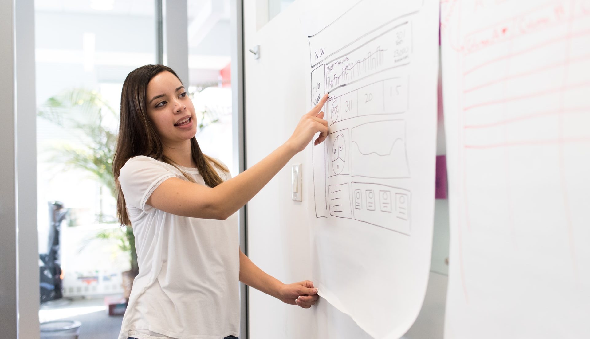 Woman pointing at a graph and explaining a concept.