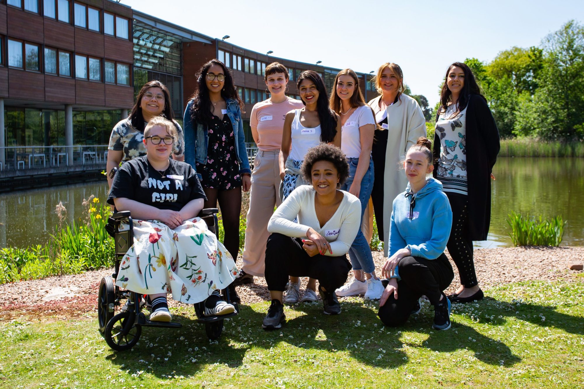 A group of young women pose for the camera on a sunny day