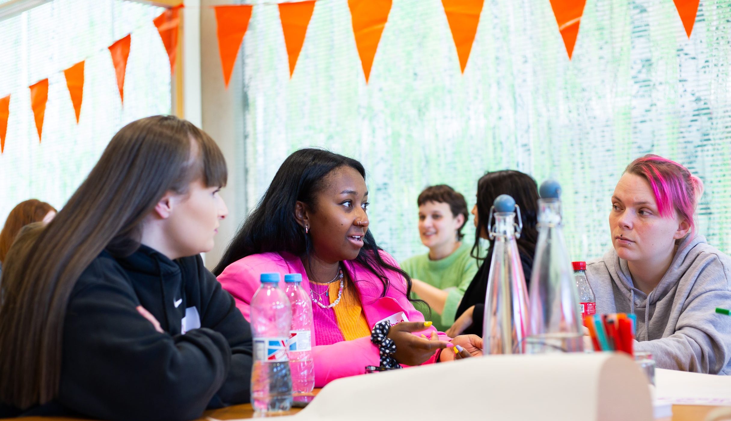 A group of women talk together sat at a table