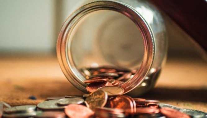 Money coins spilling out of a jar