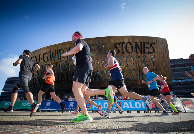 Group of runners going past the Wales Millennium Centre