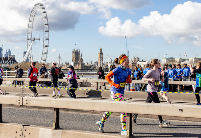 group of runners taking part in the London Landmarks Half Marathon, with the London Eye in the background.