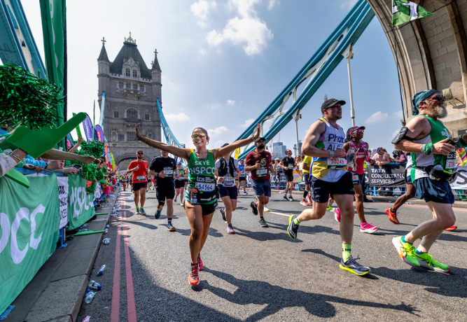 Happy runners passing over Tower Bridge during the London Marathon.