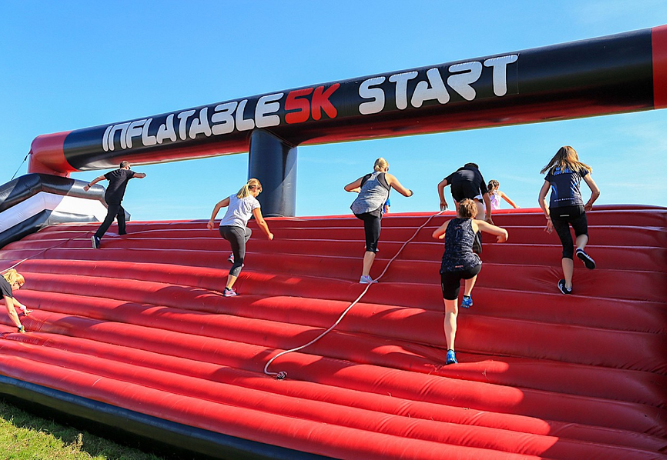 people taking part in the Inflatable 5k, running up a big inflatable ramp